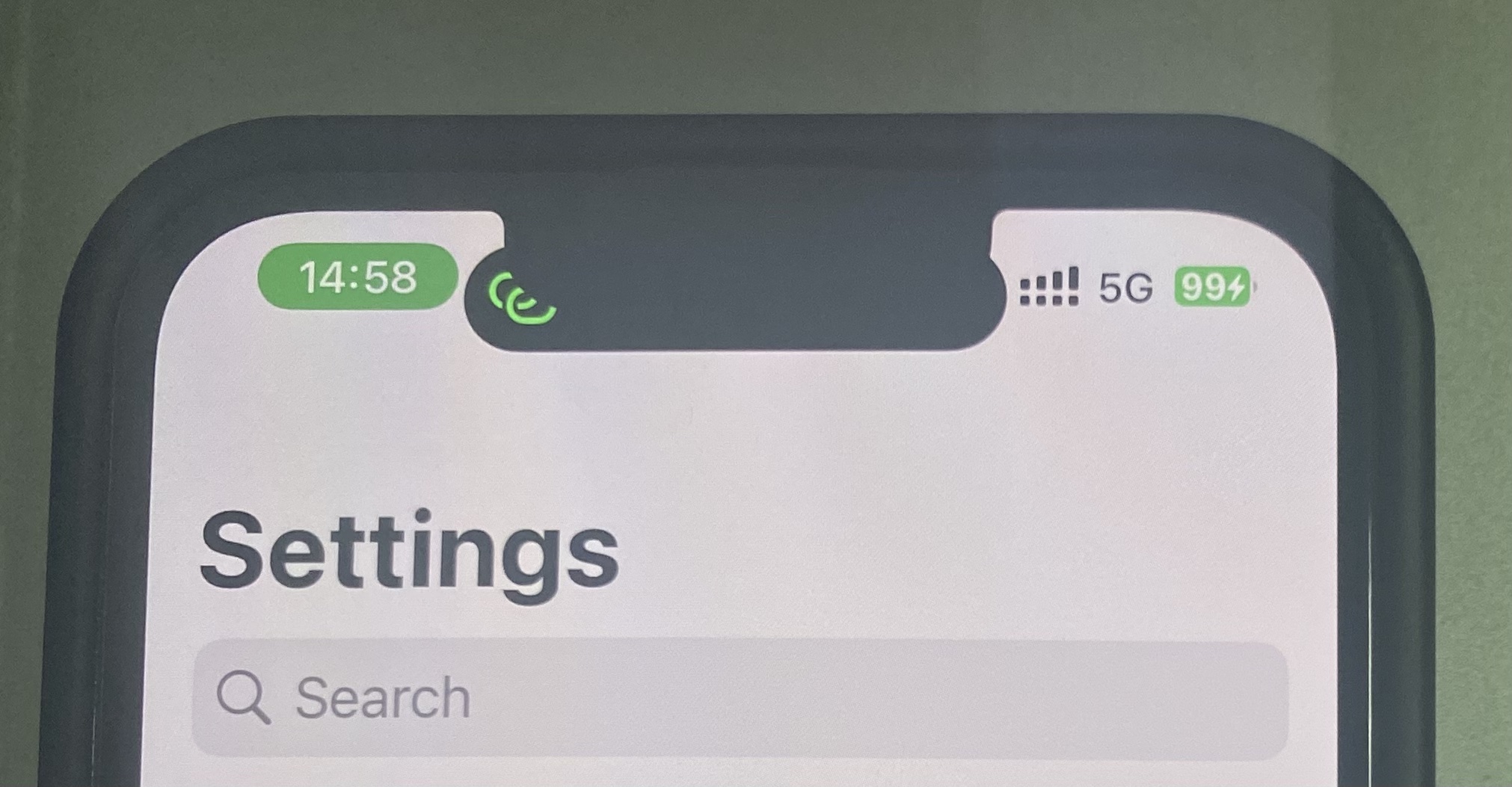 Photo of an iPhone 13 Pro with Dynamic Island content partly obscured by the physical notch and status indicators close to the cutout